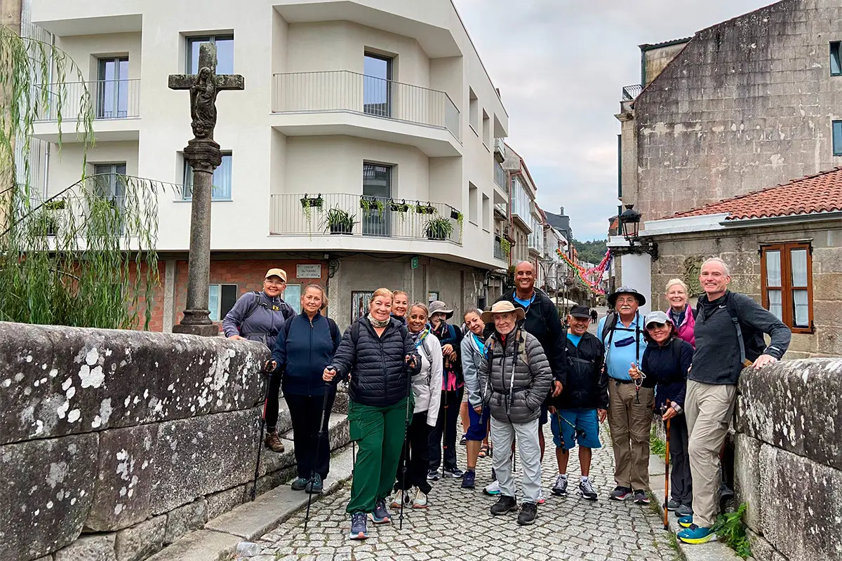 Peregrinos en el Puente del río Bermaña junto al crucero