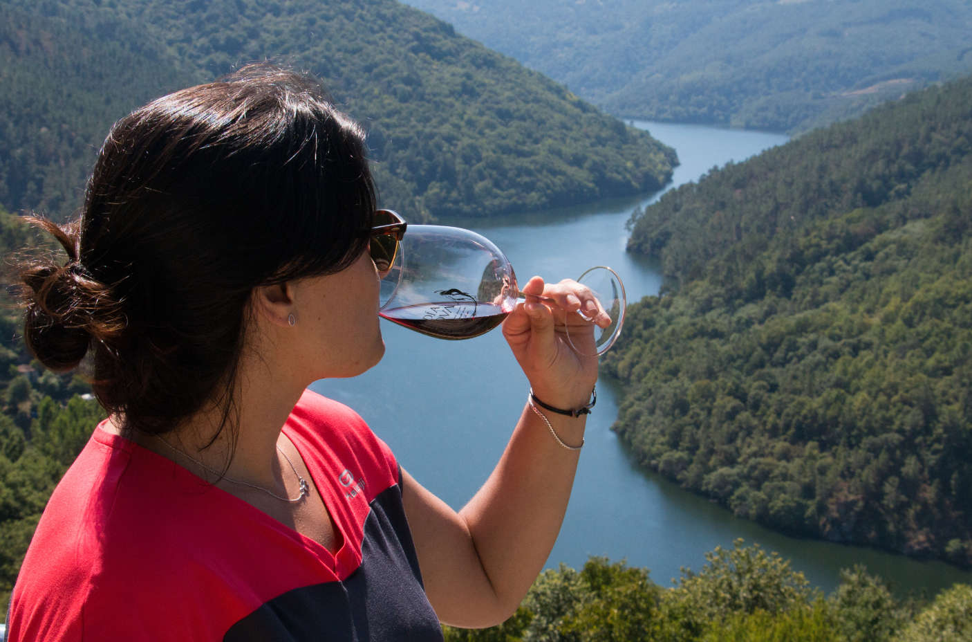 Mujer bebiendo una copa de vino frente a los Cañones del Sil